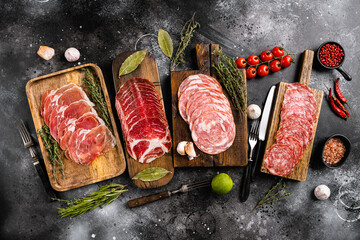 Cured italian meat Ham, prosciutto, pancetta, on black dark stone table background, top view flat...