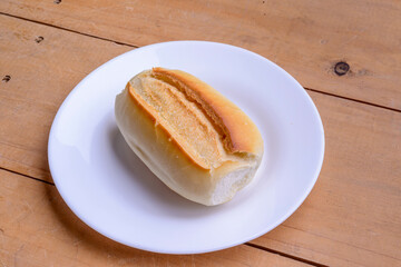 French rolls. Brazilian breads on a white plate on wooden table.