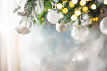 Christmas decoration with white christmas balls and fir tree branches against blurred blue...