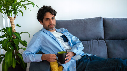 Portrait of cool and handsome man drinking morning expresso coffee on couch home