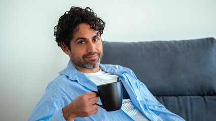 Handsome man with beard drinking morning expresso coffee with happy face smiling