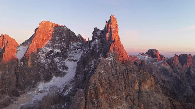 Aerial flyght over the Pale di San Martino mountain group in sunset time. Hight mountains with glacier glowing by sunset light. San Martino di Castrozza, Dolomites, Trentino, Italy.
