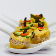 Typical Peruvian food made with yellow potatoes, lemon, yellow chili, boiled egg and black olives, avocado, tuna and mayonnaise.