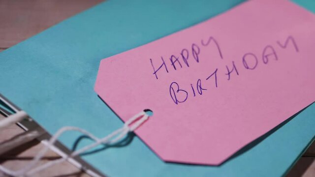 Happy birthday hand written on a gift tag 