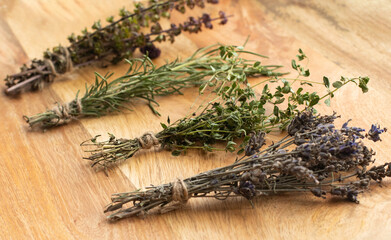 Bunches of dried lavender, thyme, rosemary and basil on a wooden background. Traditional Medicine Concept