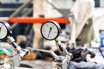 Close-up of a working pressure gauge of a hydraulic oil station in a workshop.