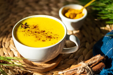 Top down view of Golden milk or Turmeric Latte cup on a straw plate stand.