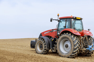 Large tractor on the field. Sowing of grain, vegetable crops.