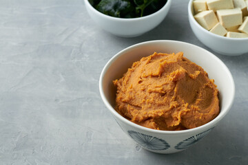 miso paste shiro miso in a bowl on grey background for miso soup with tofu wakame seaweed
