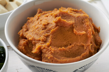 miso paste shiro miso in a bowl on white background for miso soup with tofu wakame seaweed close up