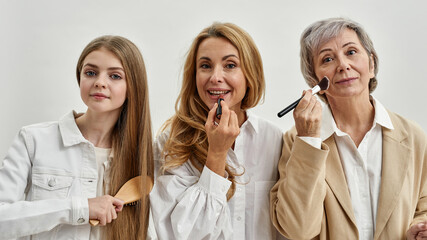 Portrait of smiling three generations of women do makeup