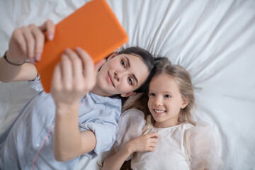 Mother and her child watching something at a mobile device