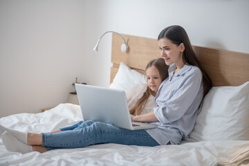 Mother and her daughter staring at the laptop