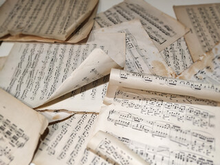 Music sheets with sheet music - the score, lie in disarray on the piano lid.  