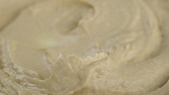 Hummus snack with golden spoon. Stir hummus with a spoon close up. 4K UHD video