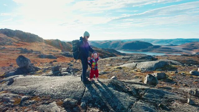 Hikers in Arctic. Aerial view of the family hiking in the Arctic terrain with kid