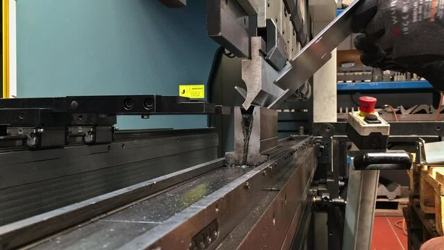 Bending sheet metal on a hydraulic machine at the factory. Bend tools, press brake punch and die. Close-up.