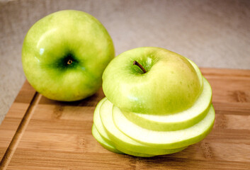 Sliced green apple on wooden cutting board