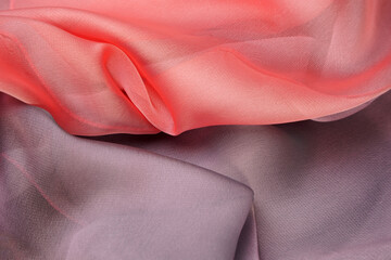 Background. The fabric of delicate pink and gray colors lies with curves and shadows. Divided into two halves.