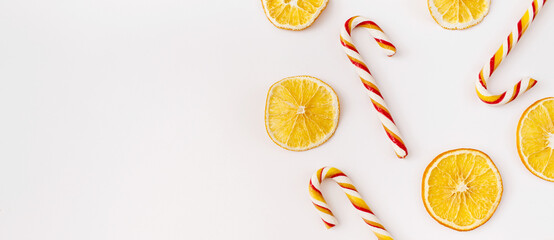 Christmas Banner. winter, new year composition. Slices of dry oranges and candies on white background. Food background. Flat lay, top view, copy space