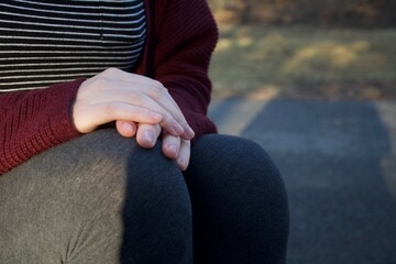 hands folded on the knee