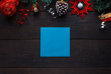 Wooden background with Christmas decorations and card with free space for greetings or a list of guests.