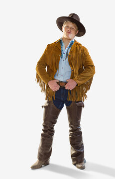 Portrait of Caucasian man dressed in a cowboy costume for Halloween smiling and making at face at camera, against a white background
