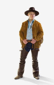 Man in a cowboy costume for Halloween smiling and making at face looking off camera, against a white background