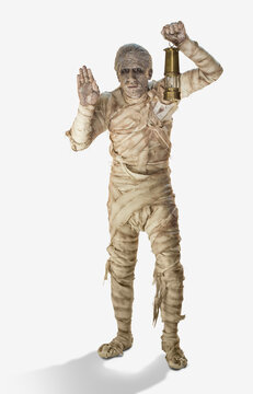 A mummy holding a lantern with one hand up looking into distance, against white background 