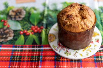 Italian Panettone on a table with a tablecloth decorated for Christmas, in approximate photo