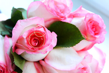 roses with two golden wedding rings