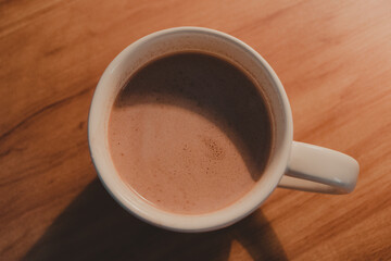 mug of hot cocoa in a wooden desk