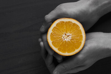 juicy orange in the hands that fills life with vitamins and health