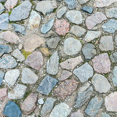 a fragment of a cobblestone pavement of different sizes and shapes. Close-up. Weathered surface