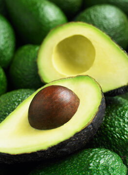 Avocado halves resting on whole avocados