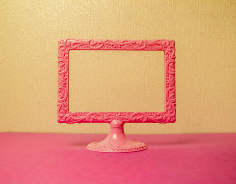 light pink photo frame on a stand on a yellow background space for text