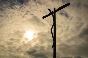 Estatua de cristo na cruz com ceu nublado por fundo