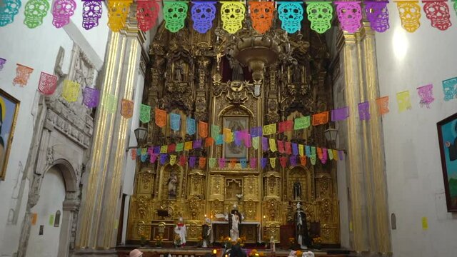 Mexican colorful tradition, three candles lighting a small offering for day of the dead with bread, sugar skull and handmade pierced papers. High quality FullHD footage