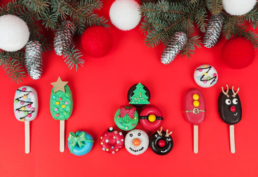 Set of different Christmas cookies donats and cakesicles on red background. Christmas decorations.
