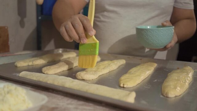 unrecognizable male pastry chef decorating baguettes