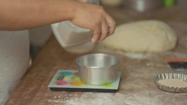 Latin man's hands weighing flour