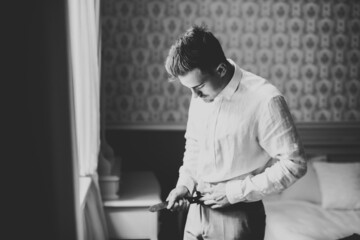 Grooms morning preparation. Handsome man getting dressed and preparing for the wedding