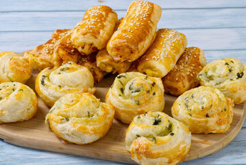 Pies and buns on a wooden table. Fresh pastries are prepared at home. A delicious crispy appetizers. close up