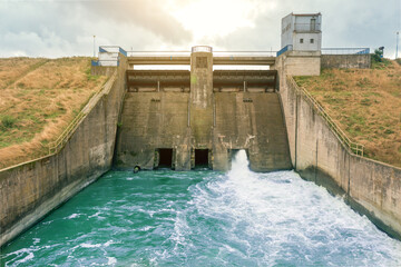 Aerial view of a large dam with a strong stream of water on the lake, in the city of Metkow Poland