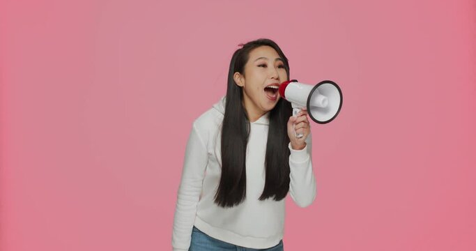 Pretty asian young girl screaming in megaphone, announce sale offer, proclaiming discount. Online store advertising