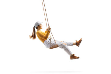 Full length profile shot of a young trendy female swinging on a wooden swing