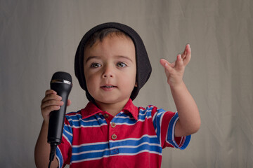 close portrait of little boy talking into microphone