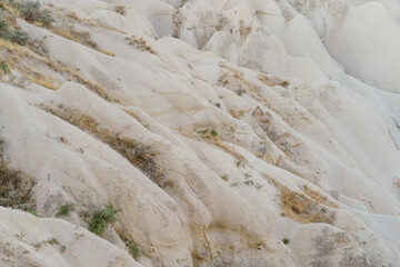Texture of a mountain sandy rock from a yellow friable old rotten stone of rock with curvy lines, layers of sand.