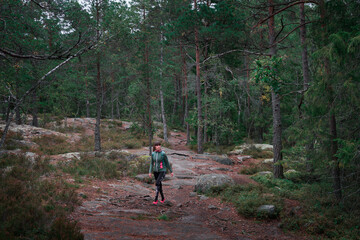 Obraz premium Woman hiking through green forest in Tyresta National Park in Sweden.