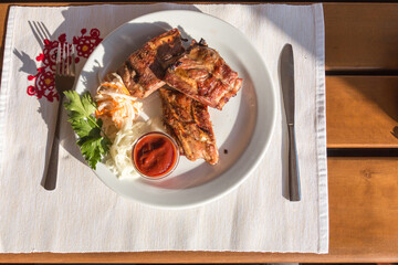 Shish kebab pork ribs on a plate, outdoor cafe, top view